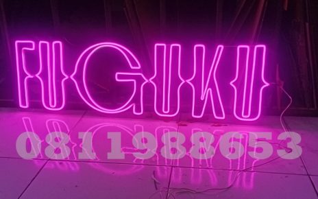 Neon flex custom tulisan FUGUKU warna pink LED terang dengan backing akrilik transparan untuk branding cafe dan bar