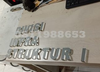 Huruf timbul akrilik custom tulisan DIVISI INFRASTRUKTUR untuk signage kantor dan papan nama gedung modern.